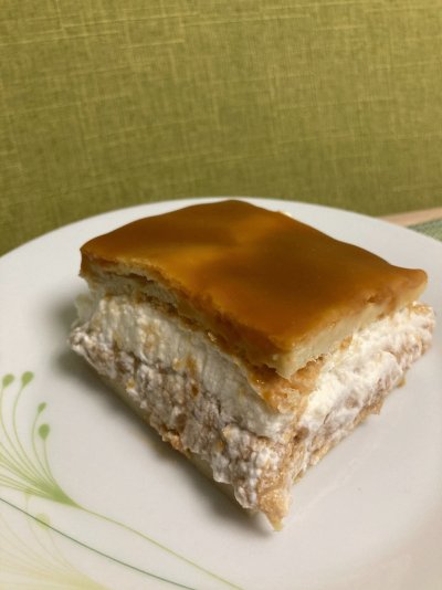 Odkrojený kousek karamelového větrníku na plech, servírovaný na bílém talíři