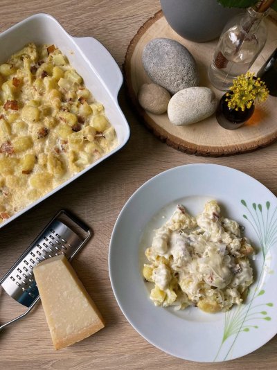 Zapečené gnocchi s květákem, servírované na bílém talíři
