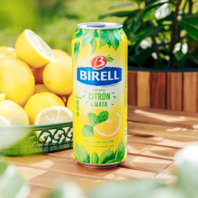 Žlutá plechovka Birell s mátovými listy a obrázkem citronu