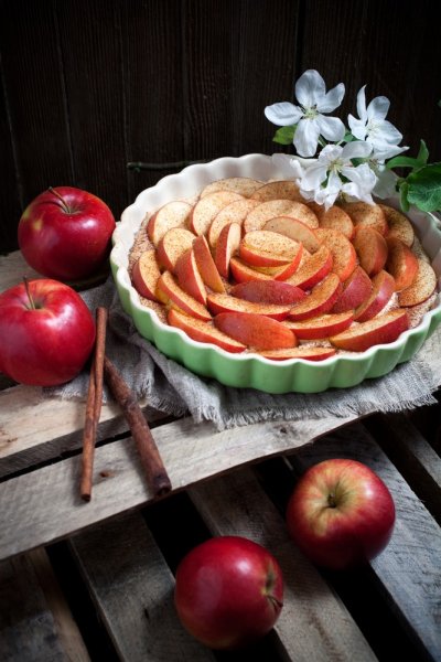 Koláč v keramické formě a ozdobený jablečnými měsíčky