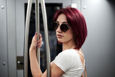 Žena s růžovými vlasy a brýlemi