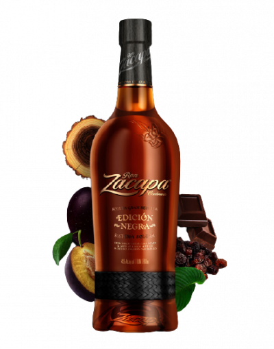 Láhev rumu Ron Zacapa Centenario, v pozadí švestky, čokoláda, rozinky a dřevo