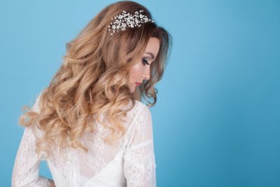 Žena ve svatebních šatech a s rozpuštěnými vlnitými vlasy