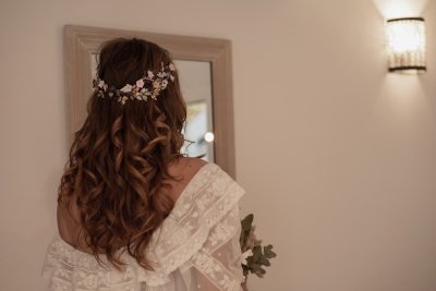 Žena ve svatebních šatech a s rozpuštěnými vlnitými vlasy