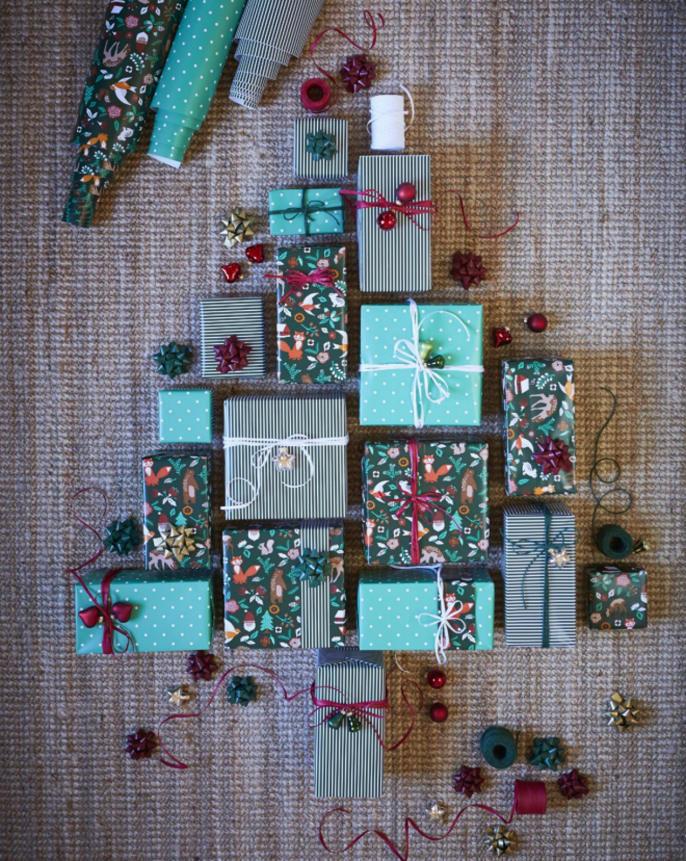 Dárečky zabalené do dárkových papírů IKEA vyrovnané tak, aby tvořily siluetu stromečku