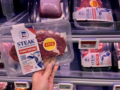 Ruka držící balený hovězí steak v supermarketu