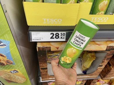 Ruka držící tubu bramborových lupínků v supermarketu