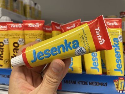 Ruka držící kondenzované mléko Jesenka v tubě v supermarketu