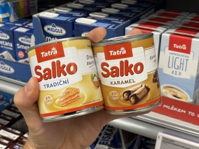 Ruka držící kondenzovaná mléka Salko v plechovce v supermarketu