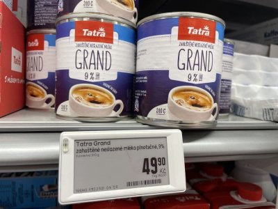 Zahuštěné mléko v plechovce v regálu supermarketu