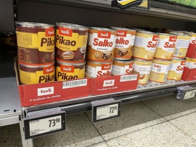 Kondenzovaná mléka Pikao a Salko v regálu supermarketu