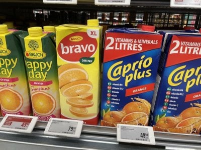 Pomerančové džusy v regálu supermarketu
