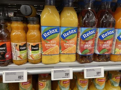 Pomerančové džusy v regálu supermarketu