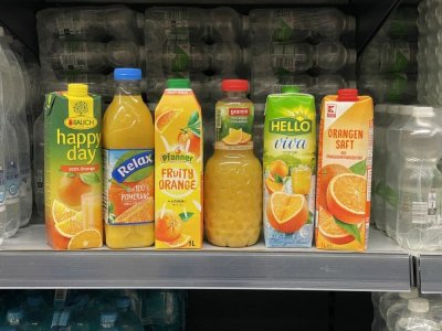 Pomerančové džusy v regálu supermarketu