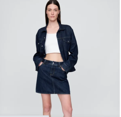 Modelka v bílém crop topu, džínové bundě a džínové sukni