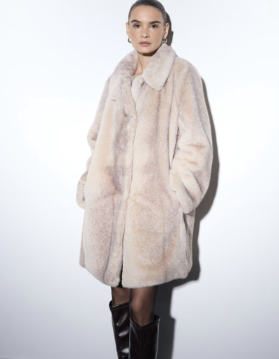 Modelka ve světlém kabátu z umělé kožešiny