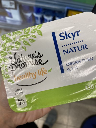 Ruka držící balení skyru v supermarketu