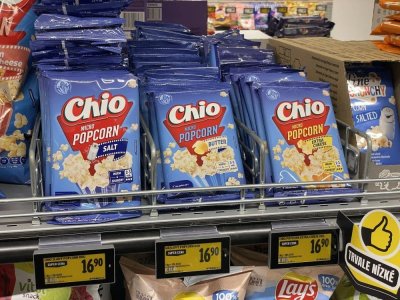 Balení popcornu v regálu supermarketu