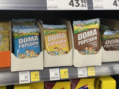Balení popcornu v regálu supermarketu