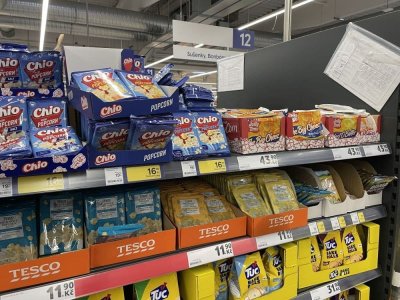 Různá balení popcornu v regálu supermarketu