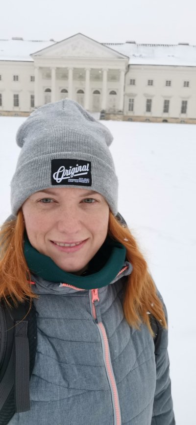 Žena v šedé čepici a zimní bundě