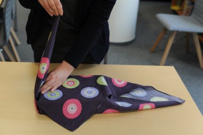 Žena balí dárek do čtvercového šátku