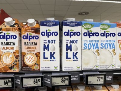 Rostlinná mléka v produktových obalech v regálu supermarketu