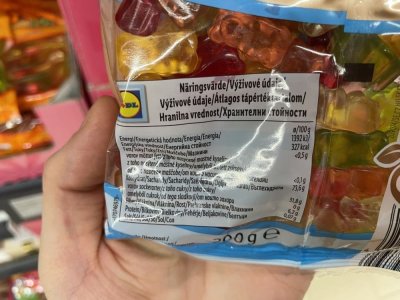 Ruka držící balení želatinových bonbonů v supermarketu