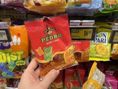 Ruka držící balení želatinových bonbonů v supermarketu