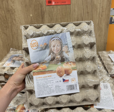 Ruka držící plato vajec v supermarketu