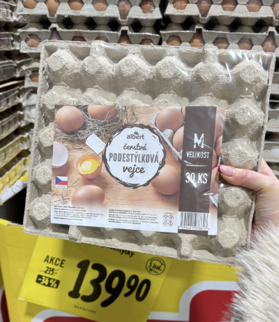 Ruka držící plato vajec v supermarketu