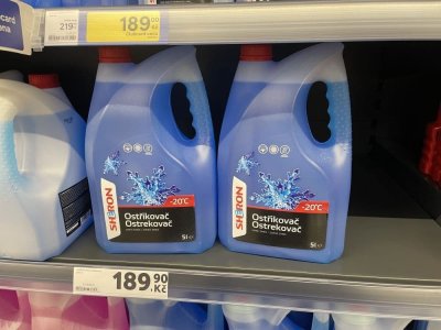 Zimní směsi do ostřikovačů v regálu supermarketu