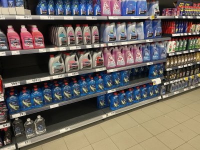 Zimní směsi do ostřikovačů v regálu supermarketu