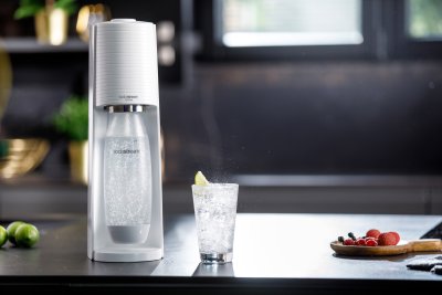 Bílý výrobník SodaStream, sklenice vody s citronem