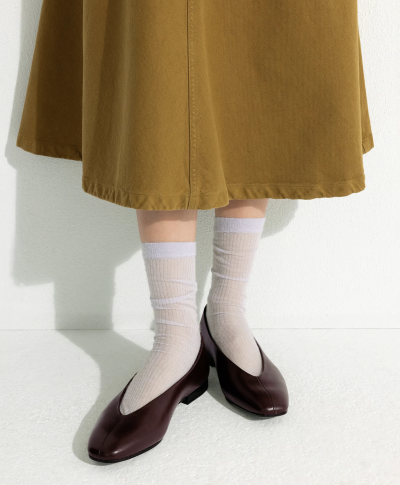 Žena v sukni a balerínách