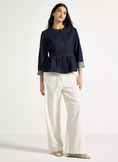 Modelka v bílých kalhotách a džínové bundě