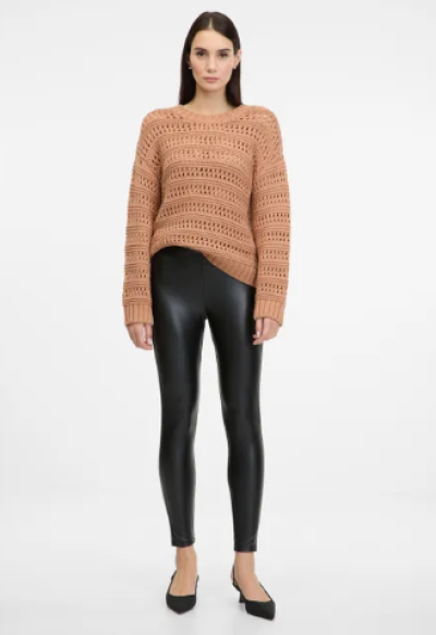 Modelka v černých legínách a béžovém svetru