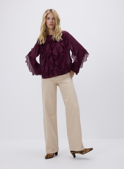 Modelka ve světlých kalhotách a vínové halence