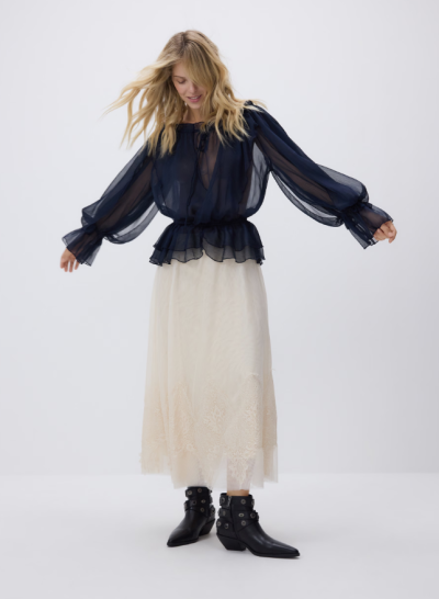 Modelka v bílé sukni a modré halence