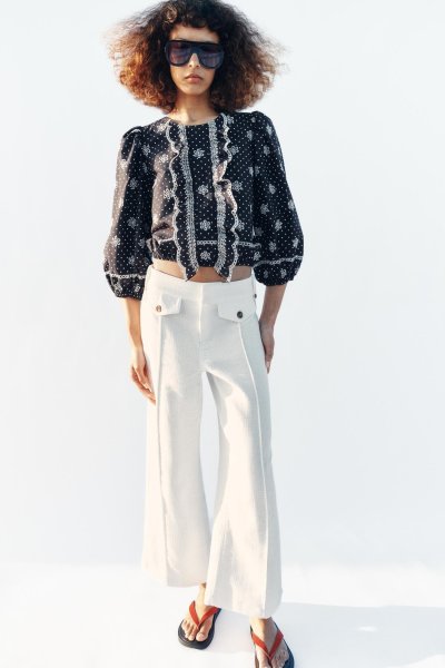 Modelka v blůze a bílých kalhotách