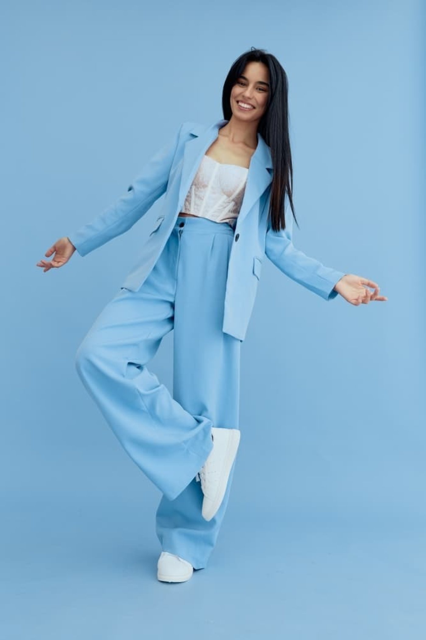 Mladá žena v modrém saku a kalhotách