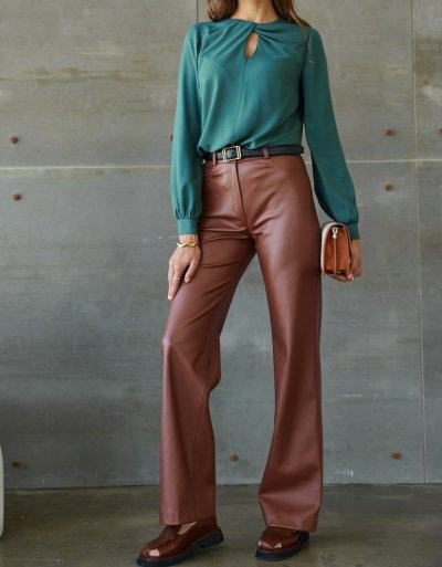 Žena v modrozelené halence a hnědých kalhotách