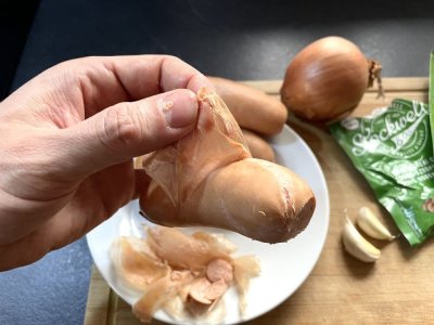 Muž odstraňuje střívko ze špekáčku