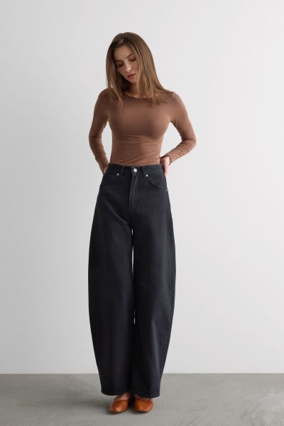 Žena v halence a širokých kalhotách