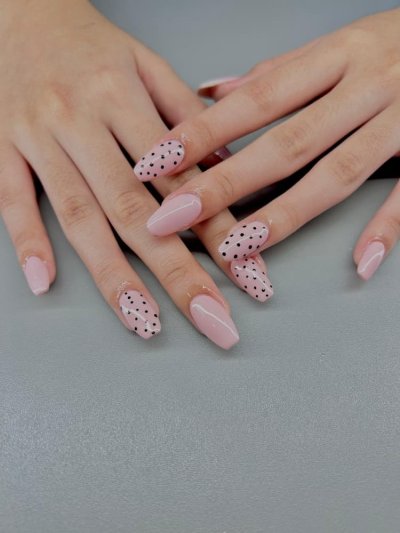 Světle růžové nehty s drobnými černými puntíky