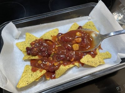 Nachos, rajčatový protlak a fazolová směs na plechu vyloženém pečicím papírem