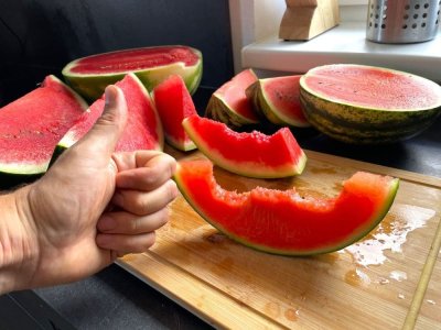 Muž dává palec nahoru před rozkrojeným melounem