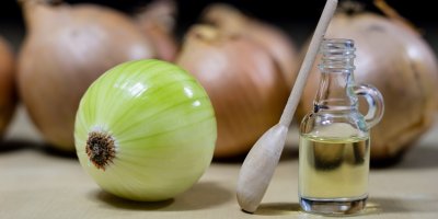 Oloupaná cibule, lahvička se sirupem, lžíce