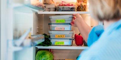 Žena vyndává z lednice krabičky s jídlem