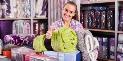 Žena vybírá povlečení a ložní prádlo v obchodě